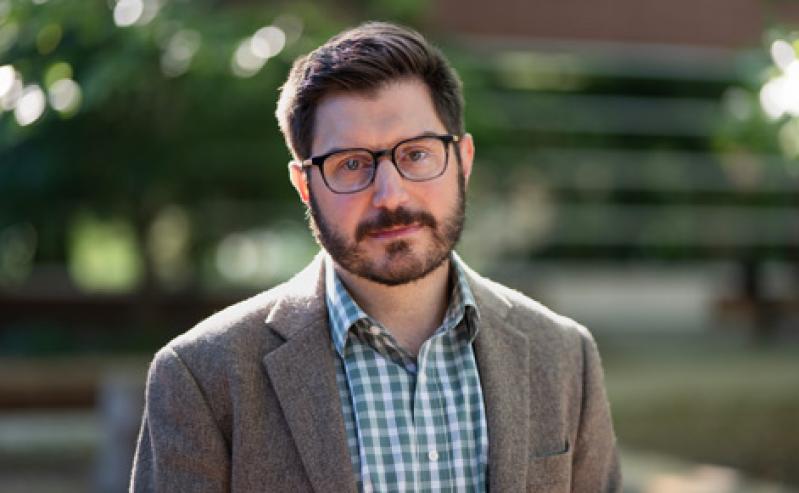 A portrait of Dr. Brendan Cantwell standing in front of Erickson Hall